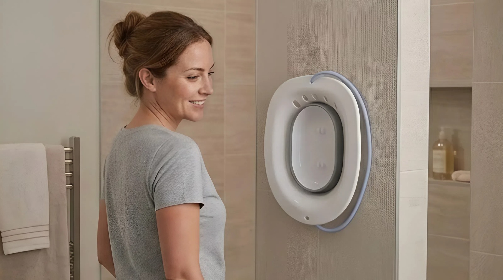 Woman in a bright bathroom beside a portable AquaNési bidet